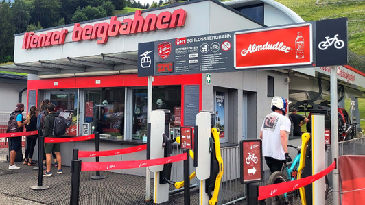 Clock panel with Almdudler advertising space at the valley station of the Schloßbergbahn in the Hochstein hiking area, Lienz in East Tyrol