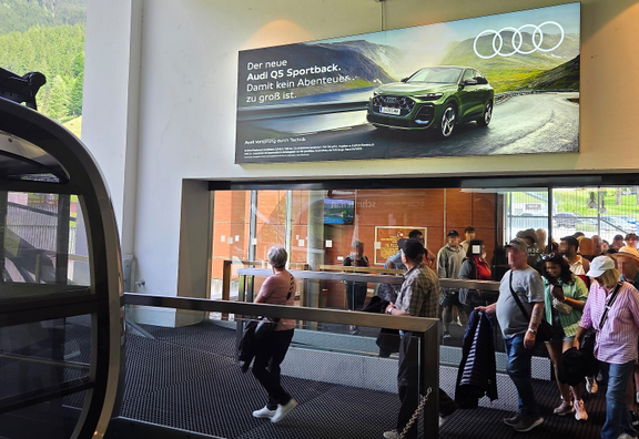 hinterleuchtetes Outdoor Impact mit Audi-Sujet an der Talstation der Schmittenhöhebahn im Skigebiet in Zell am See, Salzburg