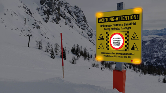 The sitour slope closure sign features a backlit closure symbol and flashing lights in the dark.