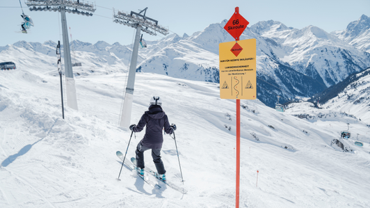Ski route board with additional danger warning sign at Ski Arlberg, St. Anton